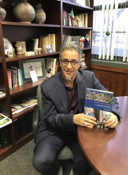 Joseph Sciorra inside the Coccia Institute Conference Room with his book "Built with Faith"