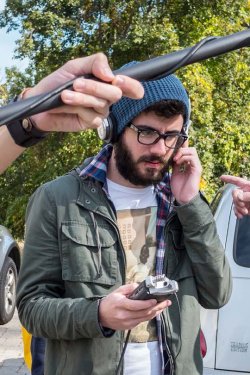 Photo of student reviewing sound recording while positioning boom mic.