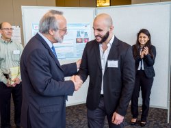 Dean Prezant congratulates first-place winner Rabih Balilli as second-place winner Shivani Patel applauds.