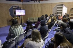 Broadcasting students watch the live feed from the "Carpe Diem" interview in an adjoining studio.