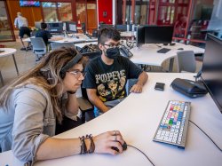 Two students working at a computer to create a film
