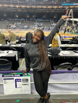 Student posing in front of basketball court