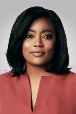 A headshot of MSNBC President Rashida Jones in a red outfit. She is looking directly into the camera.
