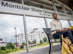 Student sitting at the Montclair Train Station waiting for a train