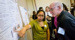 Student Research Symposium participant Serina Hernandez explains her research to Josh Weston, honorary chairman of Automatic Data Processing, Inc.