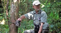 Greg Willis sets a camera trap to census animal populations.