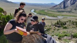 Geology students consult map on hillside