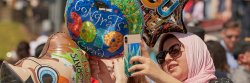 guest at convocation with balloons taking a picture