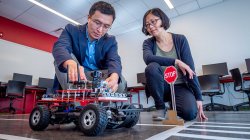 Dr. Weitian Wang adjusting a rover in the robotics lab