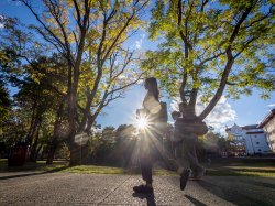 students walking outside with a sun ray