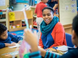 Teaching student in classroom working with children