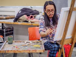 Art student painting in a classroom