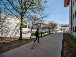 A student walking in between the Student Center and the Graduate School.