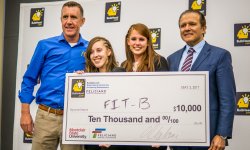 Two female students stand with $10,000 oversized check, with two male judges, at pitch contest