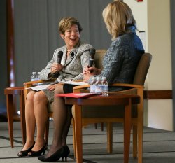 Woman being interviewed by another woman, on stage