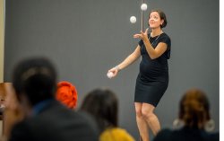 Keynote speaker Jen Slaw juggling on stage