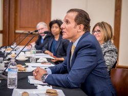 Photo of four judges, seated, at microphones.