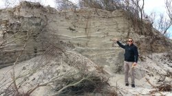 Arye Janoff standing by a large dune