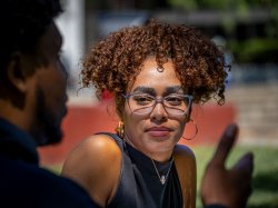Close view of a student's face as she converses with another student out of focus in the foreground.