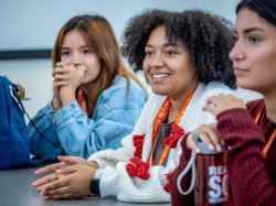 Three students at a table in a classroom