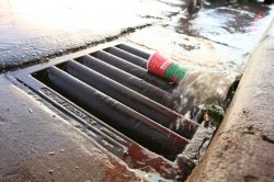 Stormwater carrying a disposable cup into the drain.