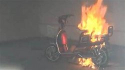 Photo of an electric scooter on fire while charging indoors.