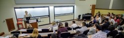 Professor and students in a lecture hall.