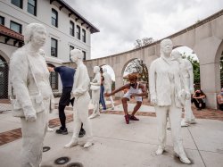 Student dancers among Street Crossing statues