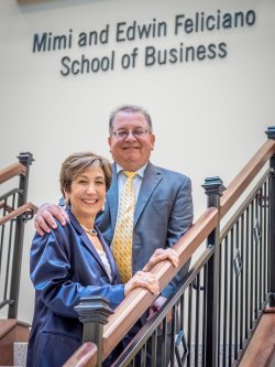 Mimi and Edwin Feliciano in front of the new Mini and Edwin Feliciano School of Business sign.
