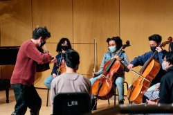 Male violinist leads group playing string instruments.