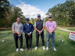 Four men standing on golf course
