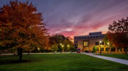 Dickson hall just after sunset surrounded by colorful trees in the fall