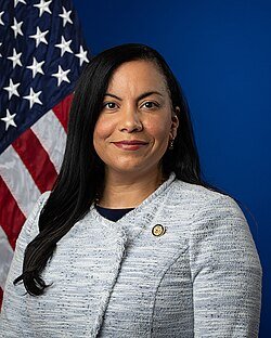 portrait of Analilia Mejia in front of American flag