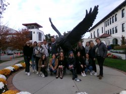 students standing for photo with statue of Red Hawk at Montclair State University