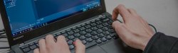 close-up view of hands on a laptop's keyboard