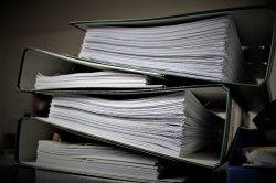 three large binders filled with documents and papers