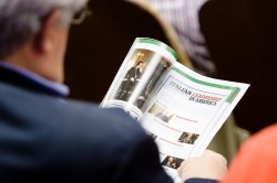 Image taken over the shoulder of someone reading a magazine or program with the headline: "Italian Leadership in America."