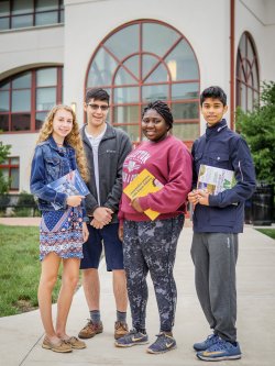 Four high school students standing outside of Schmitt Hall at Montclair State University
