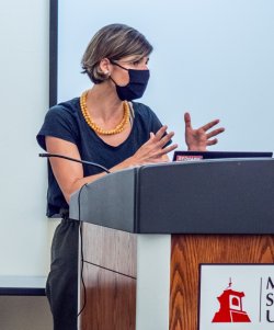 masked female faculty lecturing