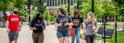 four masked students walking together on Campus