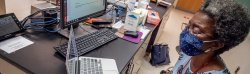Professor Sandra Adams workig on laptop in laboratory