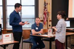 Three people discussing educational technology at a workshop.
