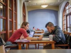 Two students working together at a table.