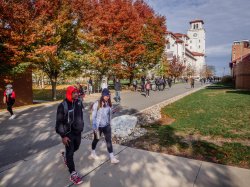 Two students on a fall day walking on campus