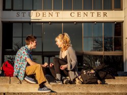 Two students sitting in front of the Student Center