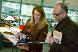 two people look at a book at the university authors event