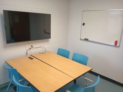 Table and chairs with monitor and whiteboard