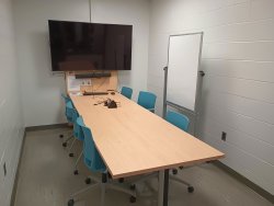 Table and chairs with monitor and whiteboard