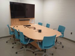 Table and chairs with monitor and whiteboard