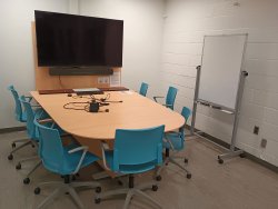 Table and chairs with monitor and whiteboard